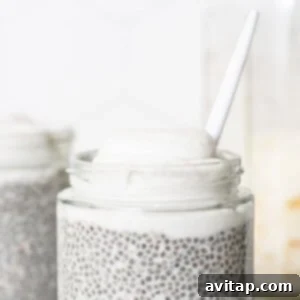Chia pudding in a jar topped with coconut whip and a spoon.