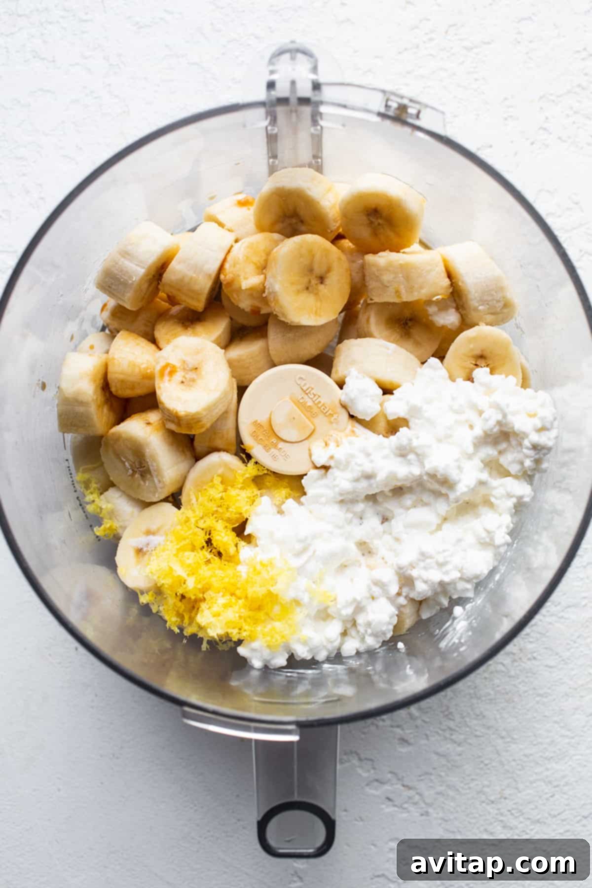 Zesty Lemon Cheesecake Nice Cream 4 A bowl containing a mix of sliced frozen bananas and cottage cheese, ready for blending.