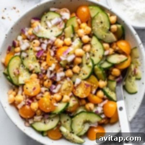 Seasoned chickpea and cucumber salad in a bowl, ready for serving.