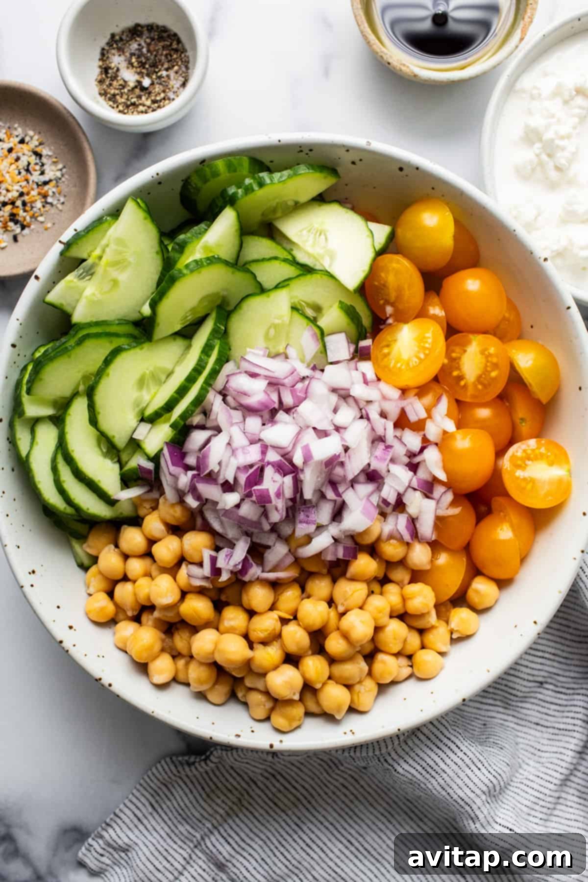 Close-up of a refreshing chickpea and cucumber salad glistening with dressing, ready to be served.