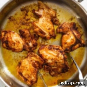 Chicken in a pan with two forks.