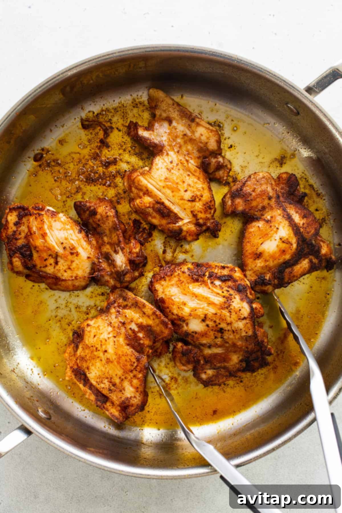 Chicken in a pan with two forks.