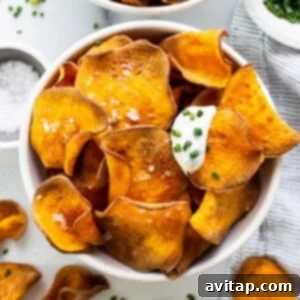 Sweet potato chips in a bowl with sour cream and parsley, a perfect homemade snack.