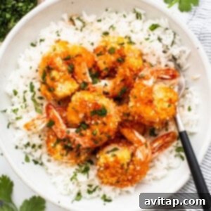 A bowl of shrimp and rice with a fork.