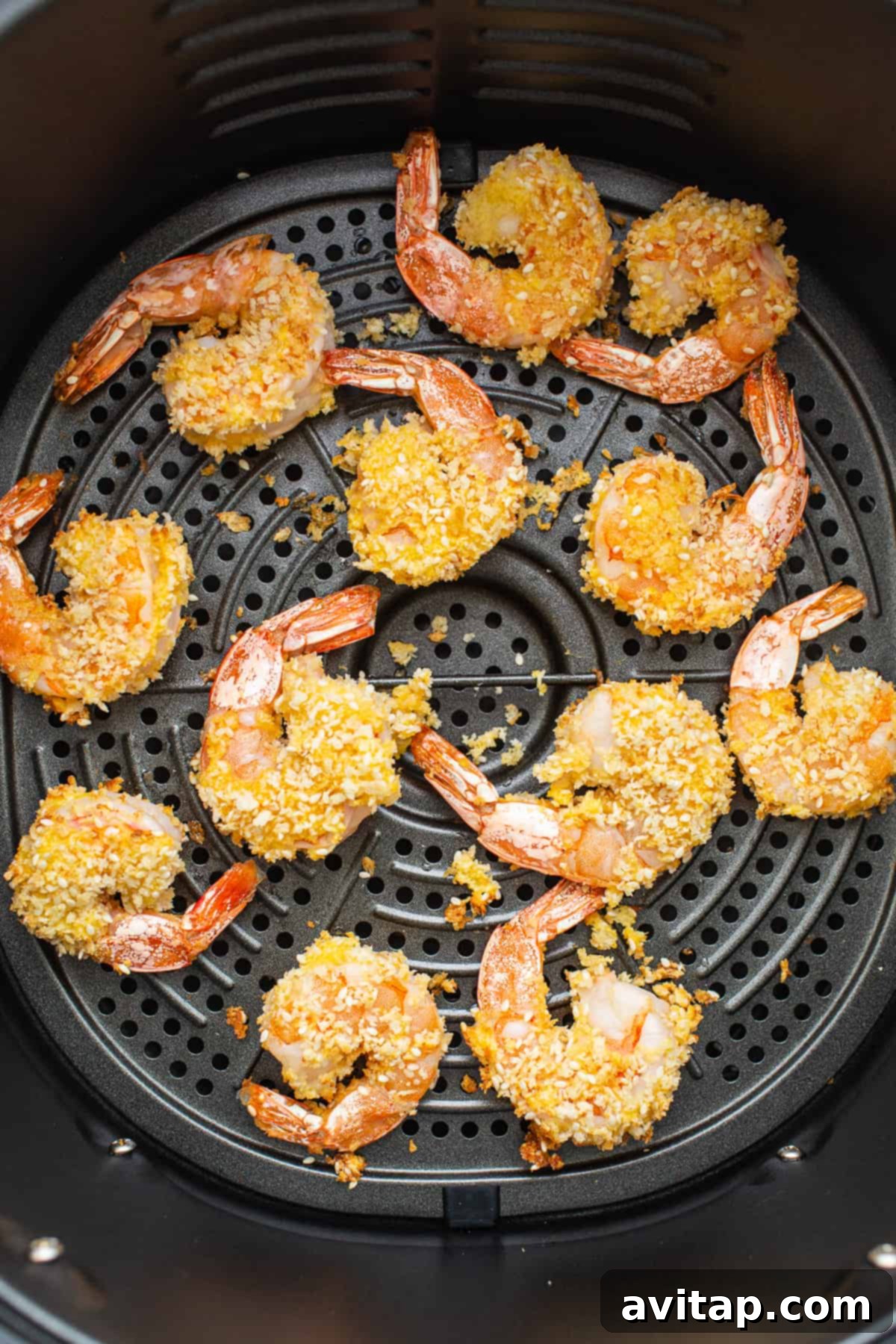 Crispy Air Fryer Firecracker Shrimp 4 Freshly air-fried shrimp, golden brown and coated with sesame seeds, resting in an air fryer basket.