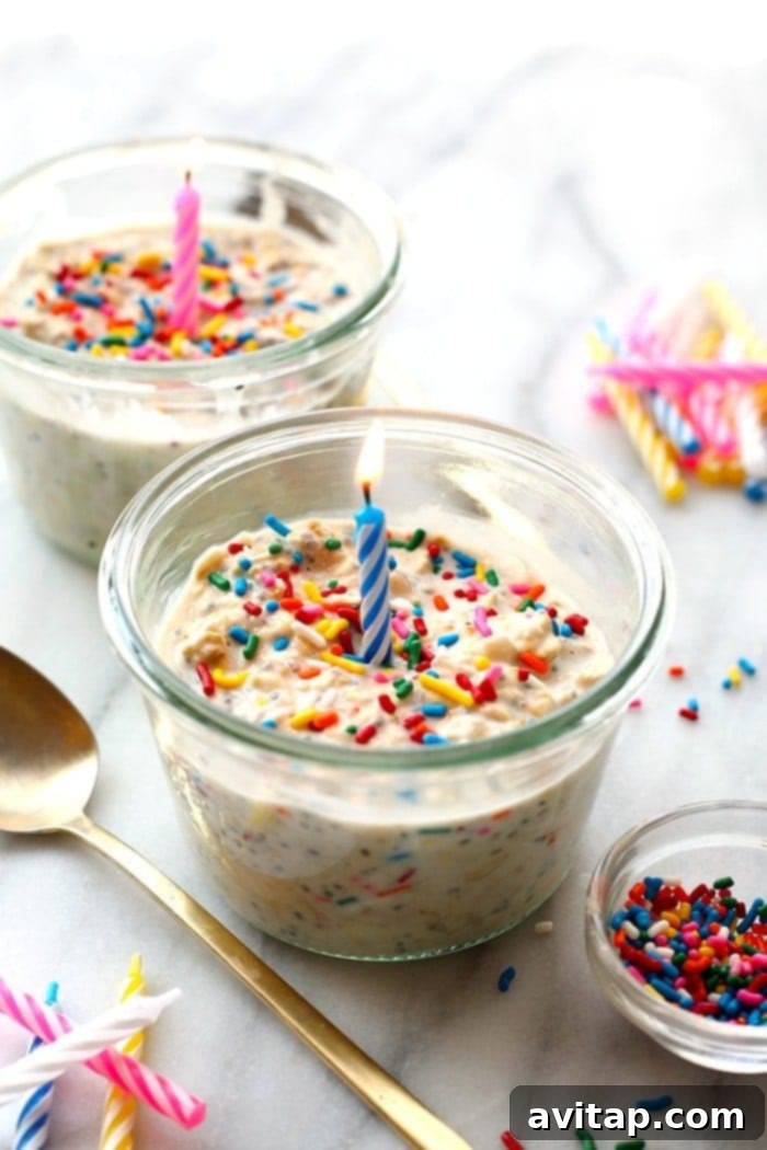A beautifully layered jar of healthy Birthday Cake Batter Overnight Oats, adorned with colorful sprinkles, ready to bring joy to your morning meal.