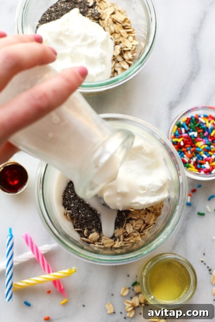 A mason jar filled with Birthday Cake Batter Overnight Oats, topped with a spoon and ready for a delicious and healthy start to the day.