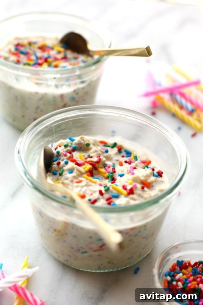 Four jars of healthy Birthday Cake Batter Overnight Oats, perfectly prepared and ready for meal prep, lined up for easy access in the fridge.