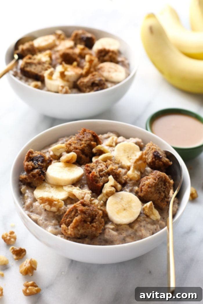 A bowl of fluffy banana stovetop oatmeal topped with fresh banana slices, cinnamon, and a drizzle of maple syrup.