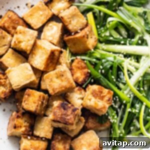 Tofu and green onions in a pan, ready to be sauced.
