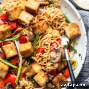 Tofu stir fry in a pan with vegetables and mushrooms, a close-up.