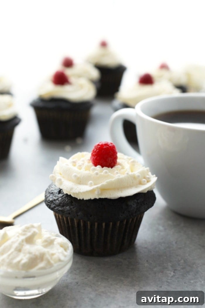 Delicious healthier chocolate cupcakes topped with a fresh raspberry, perfect for a guilt-free dessert.