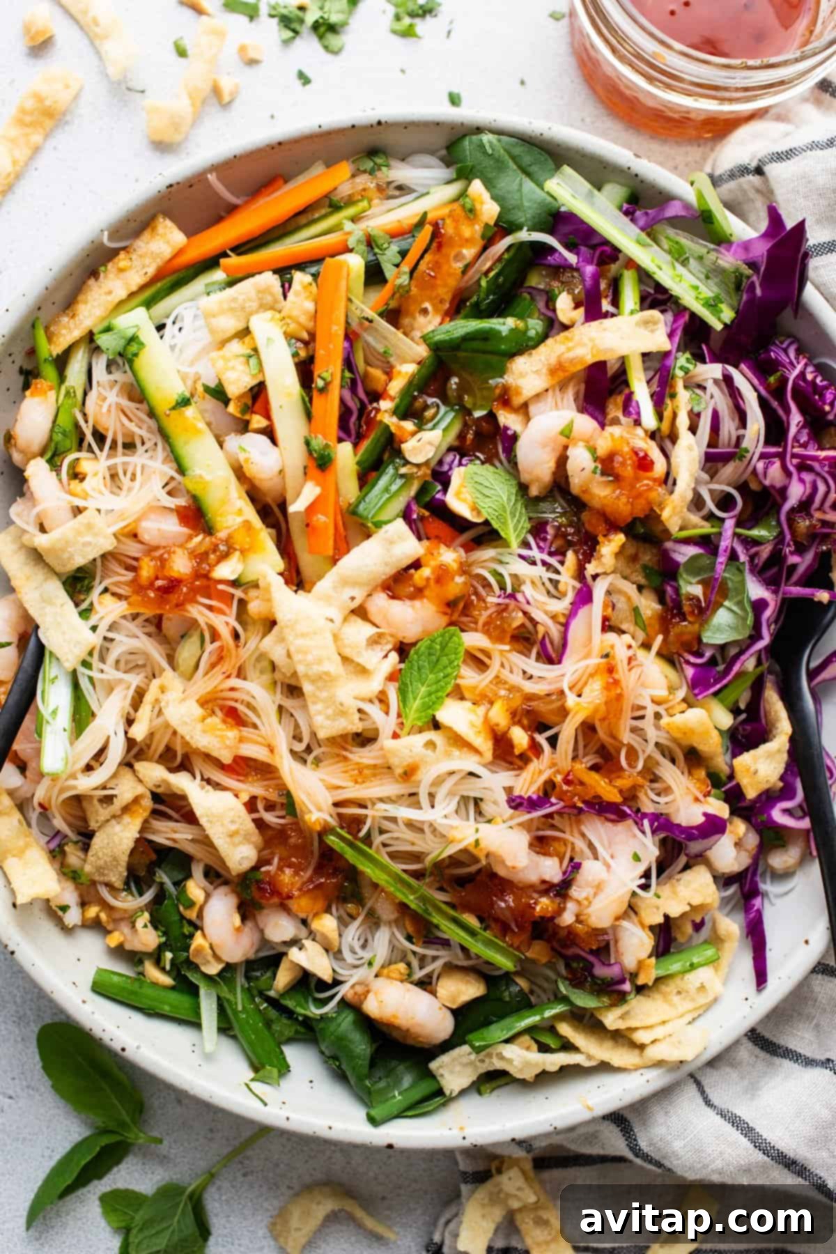 A bowl of Asian noodle salad with shrimp and vegetables.