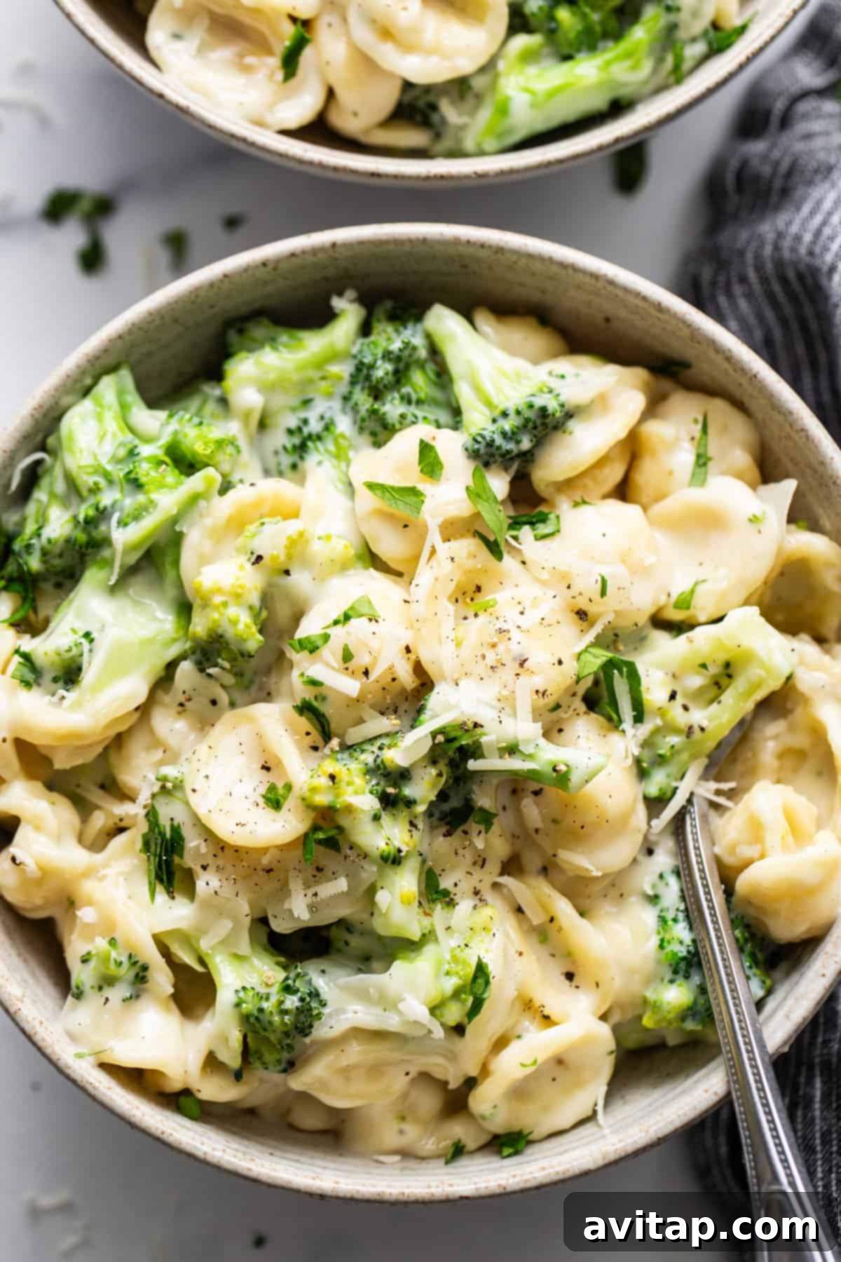 Velvety Broccoli Pasta 2 Two bowls of pasta with broccoli and parmesan cheese, ready to be served as a comforting meal.