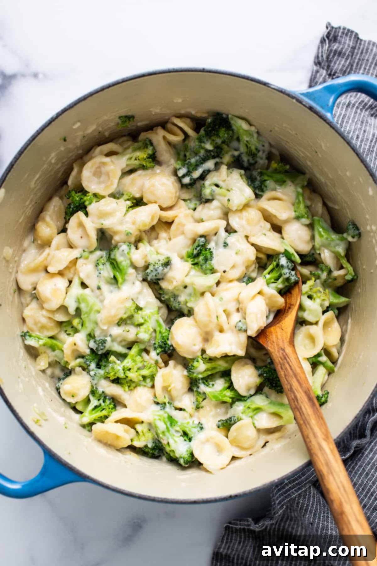Velvety Broccoli Pasta 4 A pot filled with creamy pasta, vibrant green broccoli, and melted cheese, a comforting meal.