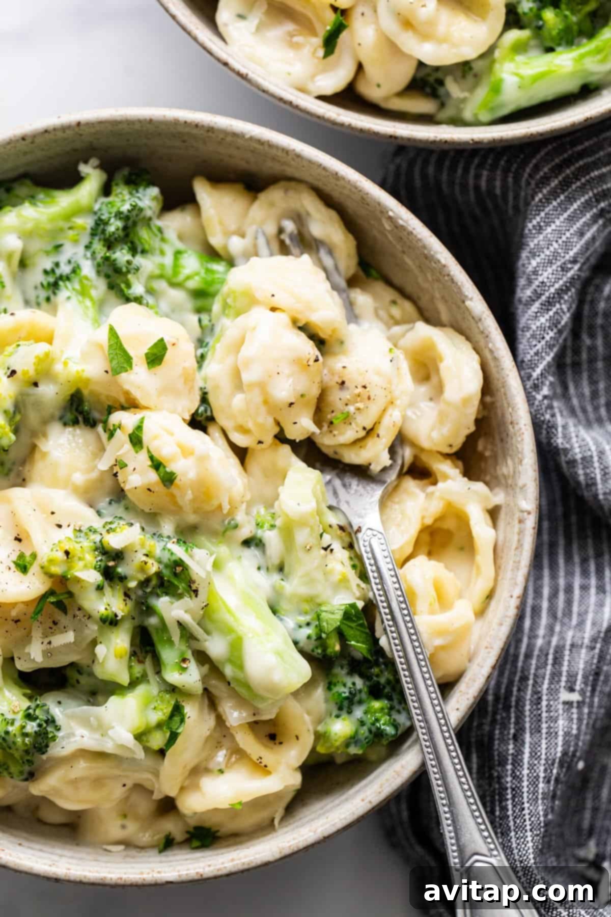Velvety Broccoli Pasta 5 Two generous bowls of creamy broccoli pasta, garnished with fresh parmesan, ready to be enjoyed.