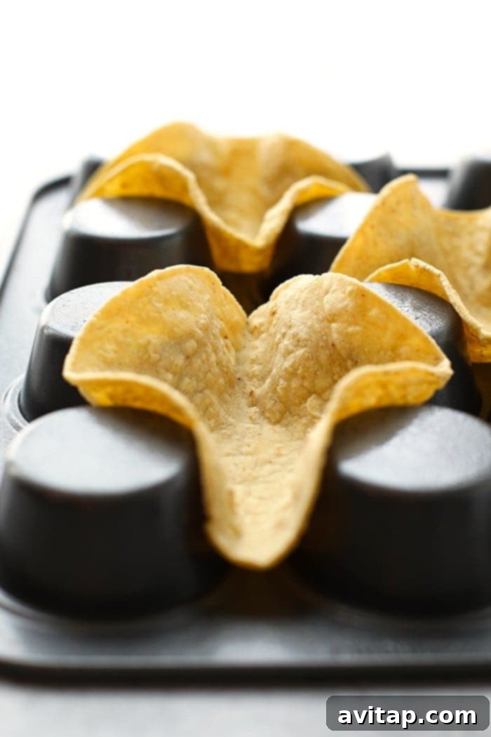 Taco shells meticulously shaped and baking in an inverted muffin tin, demonstrating the simple, effective method.