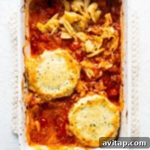 A casserole dish with creamy pasta and roasted vegetables, suggesting a meal made from the dip.