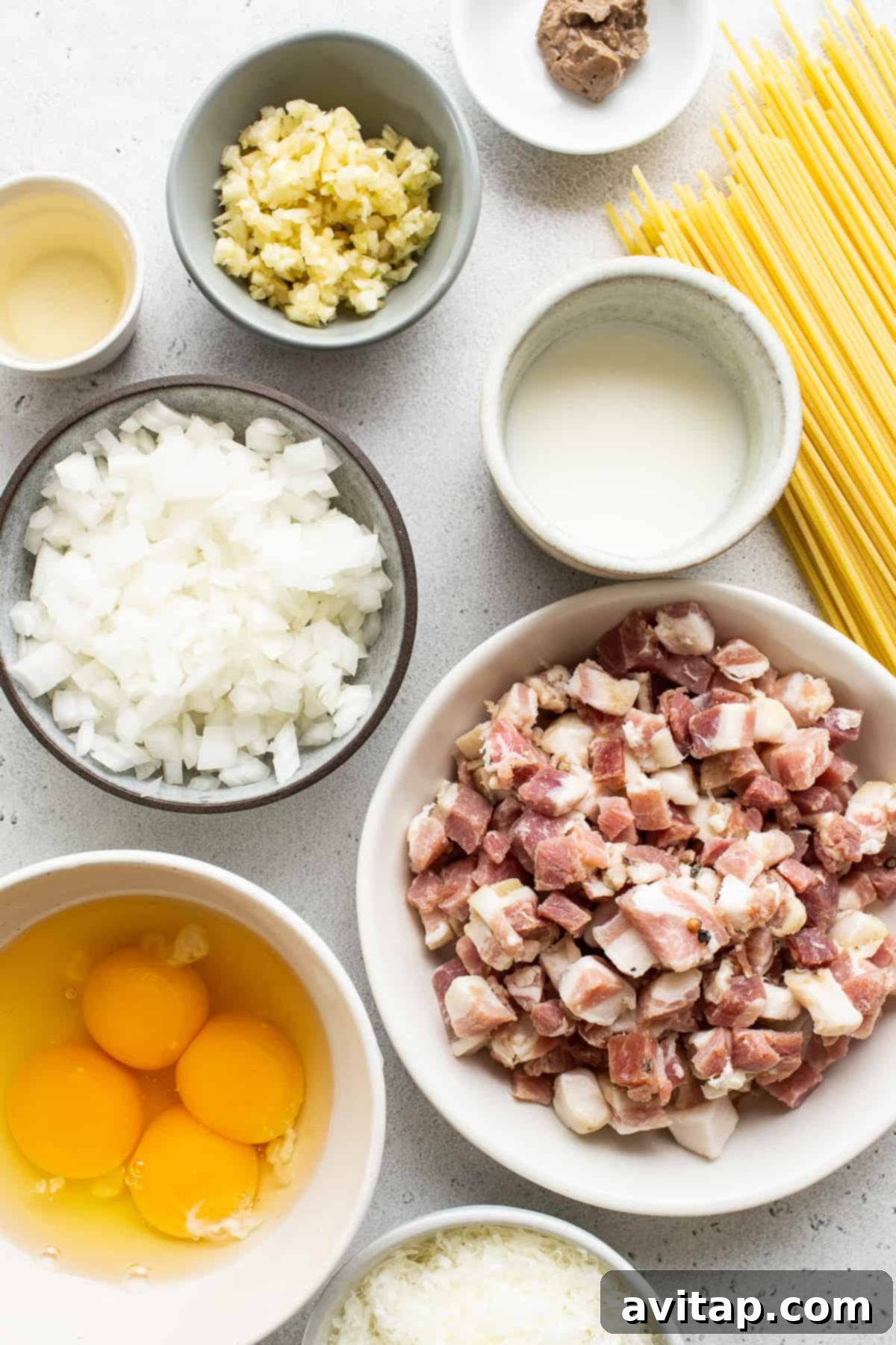 Easy Weeknight Carbonara 3 Assortment of fresh ingredients for spaghetti carbonara including spaghetti, pancetta, eggs, cheese, and garlic.