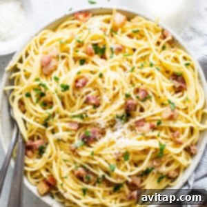 A bowl of spaghetti carbonara with bacon and parmesan.
