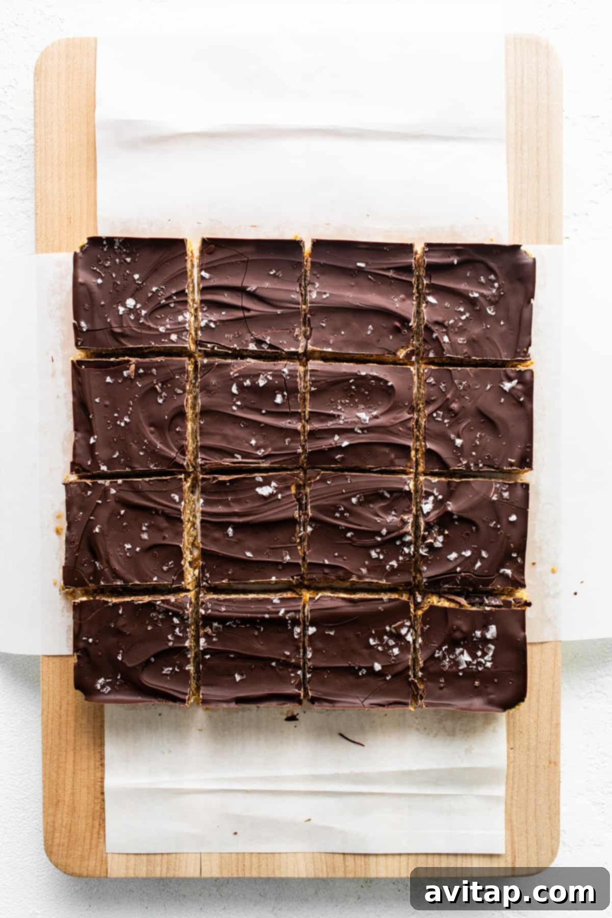Ultimate Peanut Butter Cup Oatmeal Bars 5 Perfectly cut squares of chocolate peanut butter oatmeal bars arranged on a wooden cutting board, ready for serving.