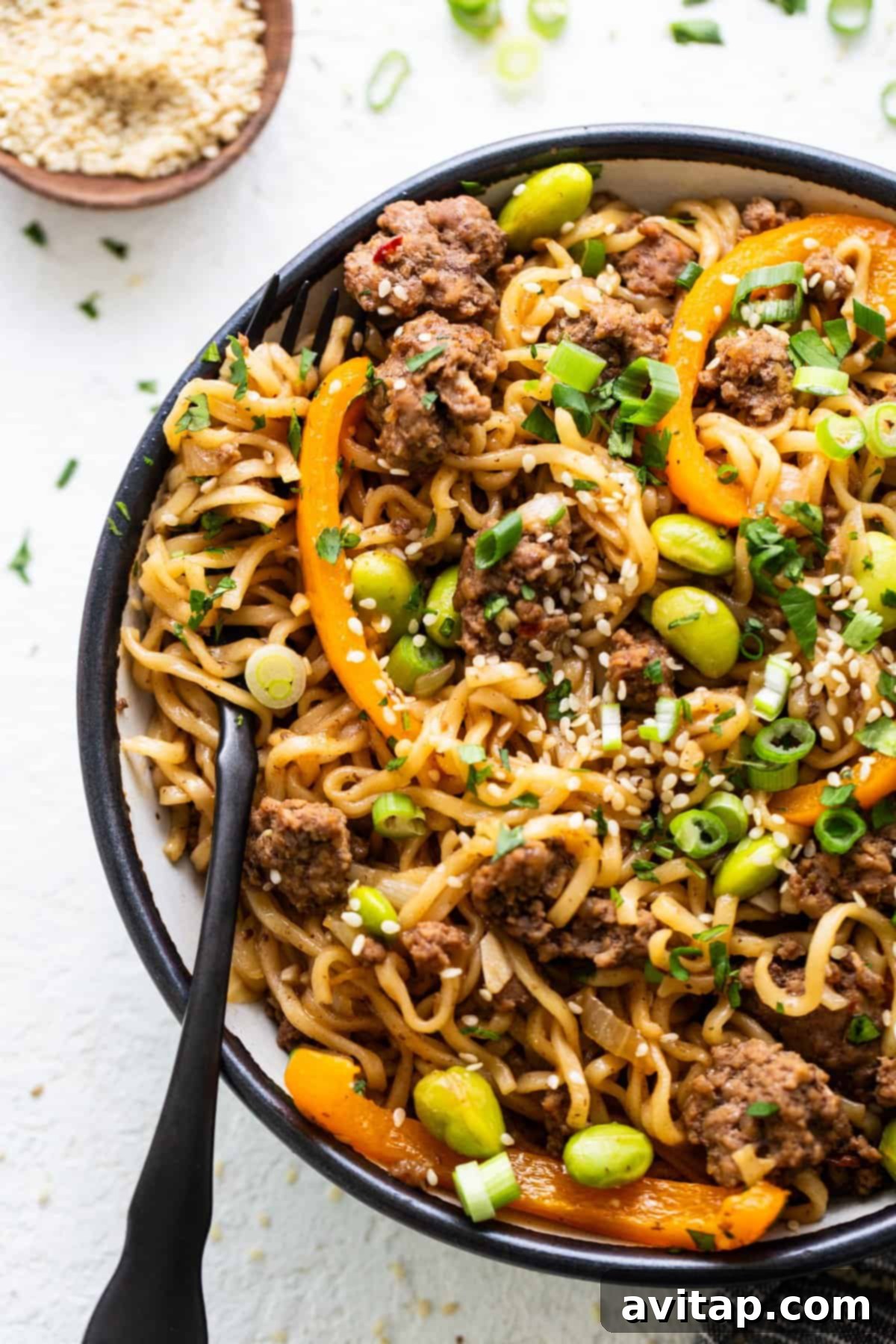 A steaming bowl of flavorful one-pot ground beef ramen noodles, garnished with fresh herbs and sesame seeds, showcasing tender beef, colorful vegetables, and perfectly cooked ramen.