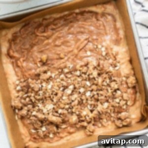 A baking pan filled with golden-brown streusel topping over a cake batter, ready for the oven.