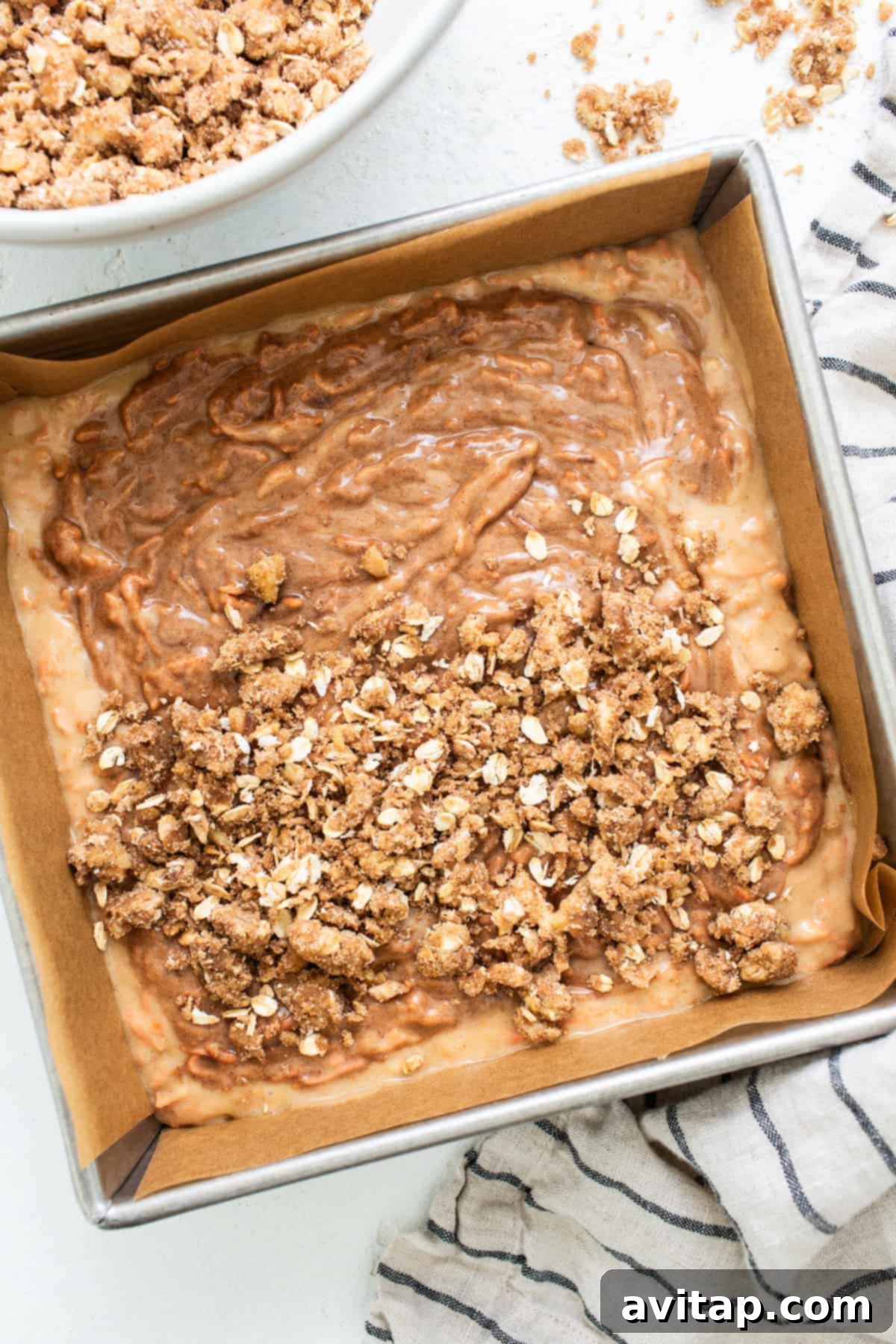 A baking pan filled with golden-brown streusel topping over a cake batter, ready for the oven.