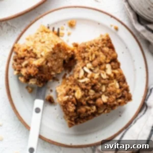 A slice of oatmeal coffee cake on a plate with a fork.