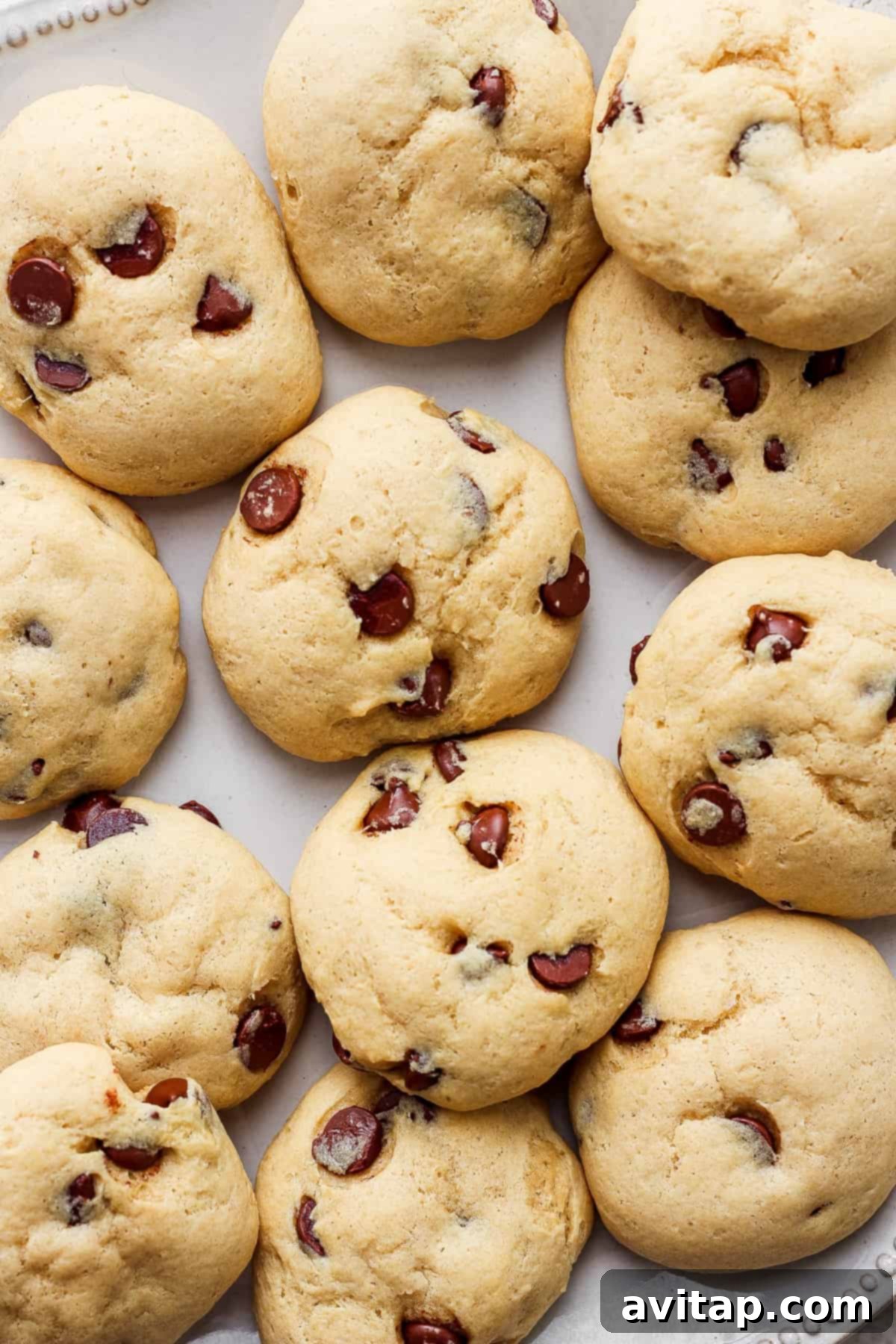 A plate of freshly baked cottage cheese chocolate chip cookies, featuring soft centers and melted chocolate chips.