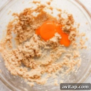A bowl showing a mixture of flour and an egg, crucial for cookie preparation.