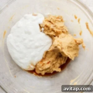 The wet ingredients for peanut butter cookie dough in a glass bowl.