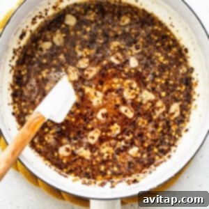 Hot honey sauce simmering in a small saucepan.
