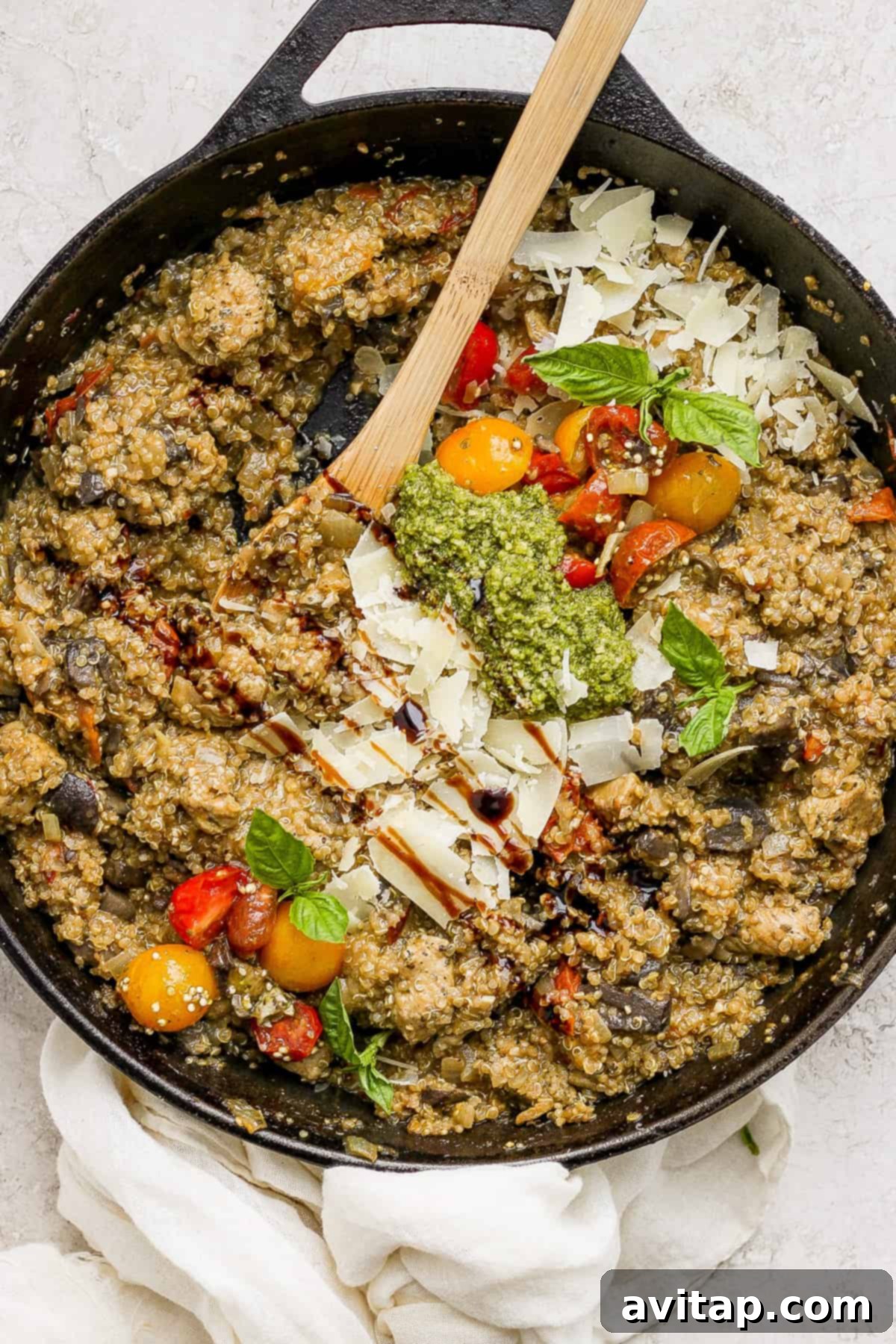 A skillet filled with vibrant vegetables and pesto, ready to be cooked down with quinoa.