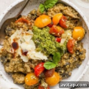 A bowl of risotto with tomatoes and pesto, visually representing the finished pesto chicken quinoa skillet.