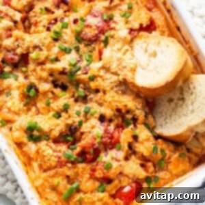 A rustic casserole dish filled with roasted chicken, tender tomatoes, and crusty bread, hinting at a cozy meal.