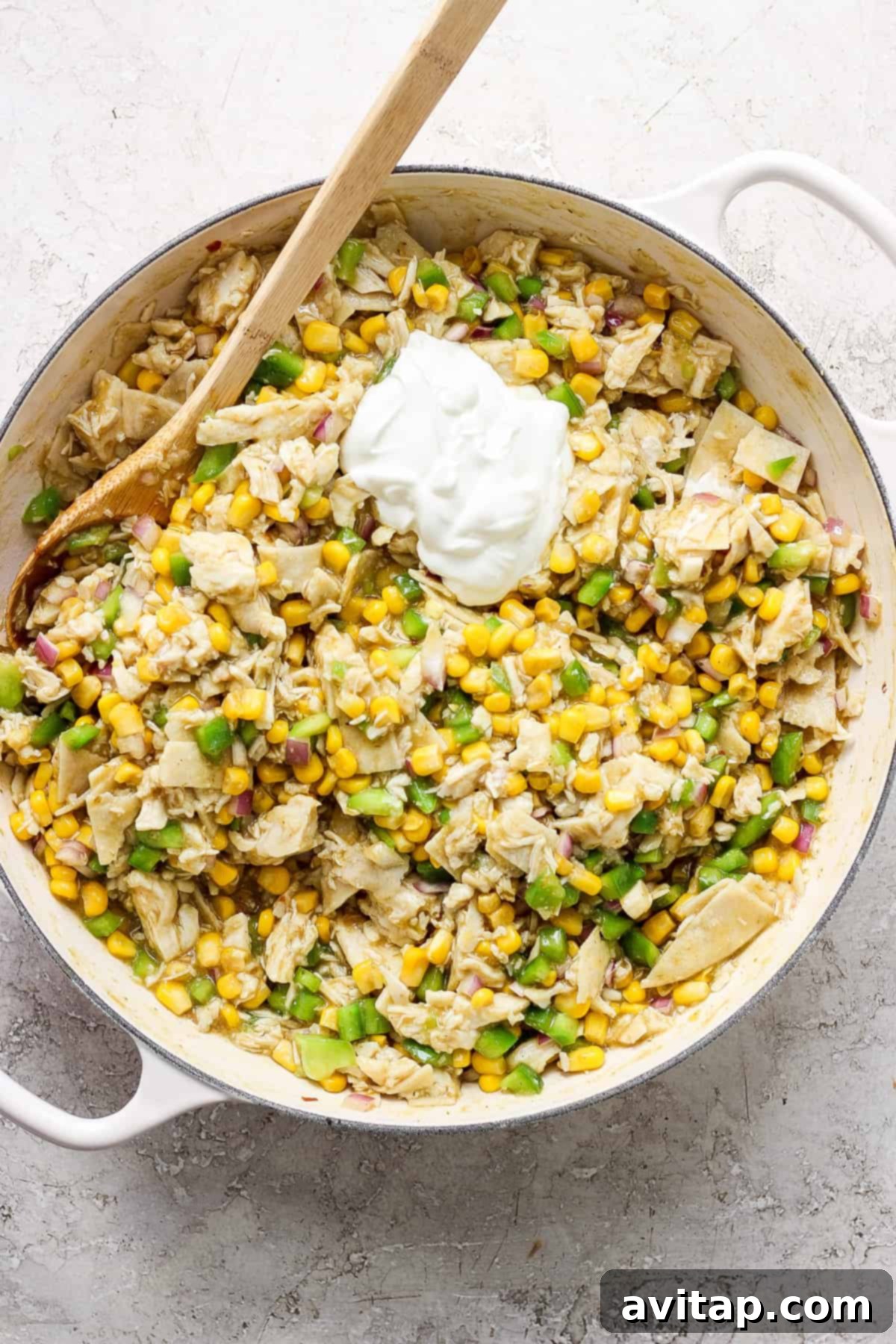 A skillet filled with corn and sour cream, showcasing the creamy sauce texture.
