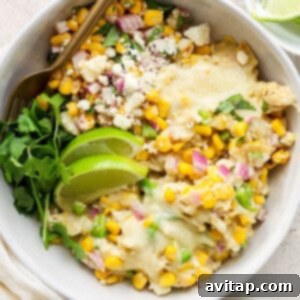 Mexican corn and chicken casserole in a white bowl, garnished with fresh herbs.