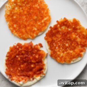 Three golden-brown cheese pancakes on a white plate with a light textured background.