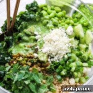 A vibrant and fully assembled Green Goddess Quinoa Salad, featuring a rich mix of greens, fluffy quinoa, creamy avocado, crisp edamame, and fresh herbs, garnished with crumbled feta cheese and ready to serve.