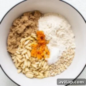A bowl with ingredients for a pumpkin bread, illustrating the process of combining dry ingredients with butter for a crumble topping.