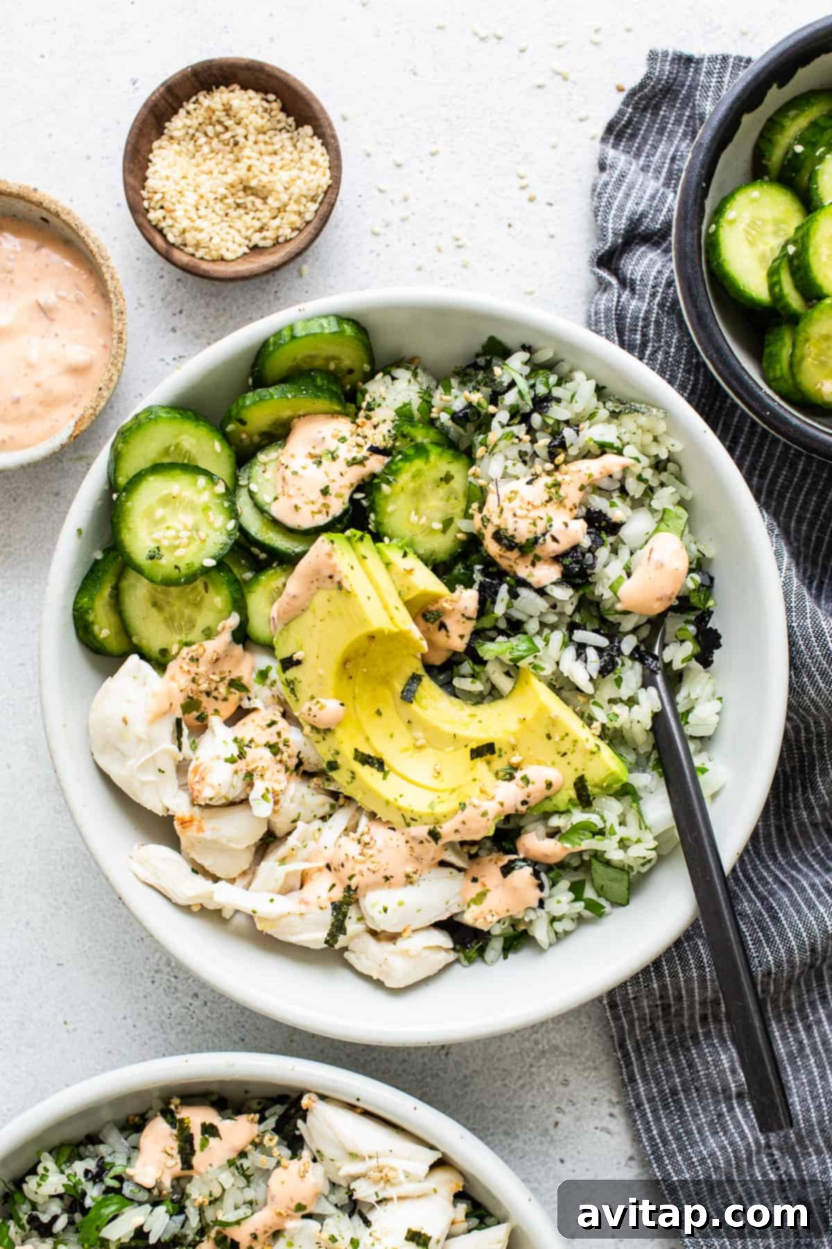 A vibrant bowl of sushi-inspired ingredients, featuring salmon, cucumber, and a creamy dressing, making for a healthy and satisfying meal.
