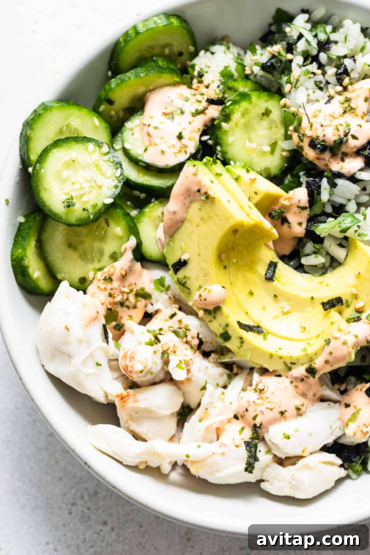 A delectable bowl of sushi with perfectly sliced cucumbers and creamy avocado, showcasing the rich textures and colors.
