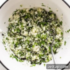 A white bowl filled with green cilantro, diced onions, and seasoning, ready for the rice.