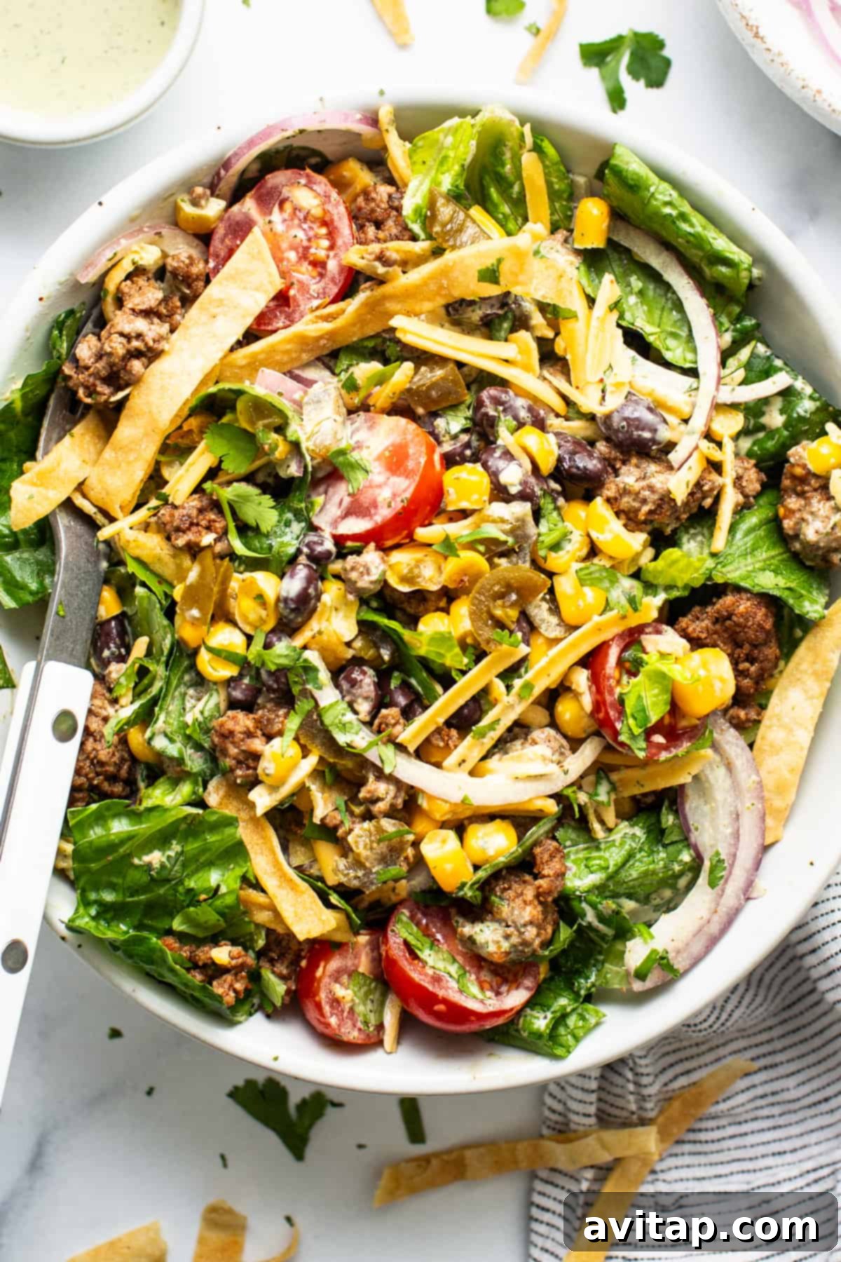 Fresh Prep Taco Bowl 2 A vibrant, beautifully arranged make-ahead taco salad featuring seasoned ground beef, crisp romaine, juicy tomatoes, black beans, corn, cheese, and crunchy tortilla strips, all ready to be tossed.