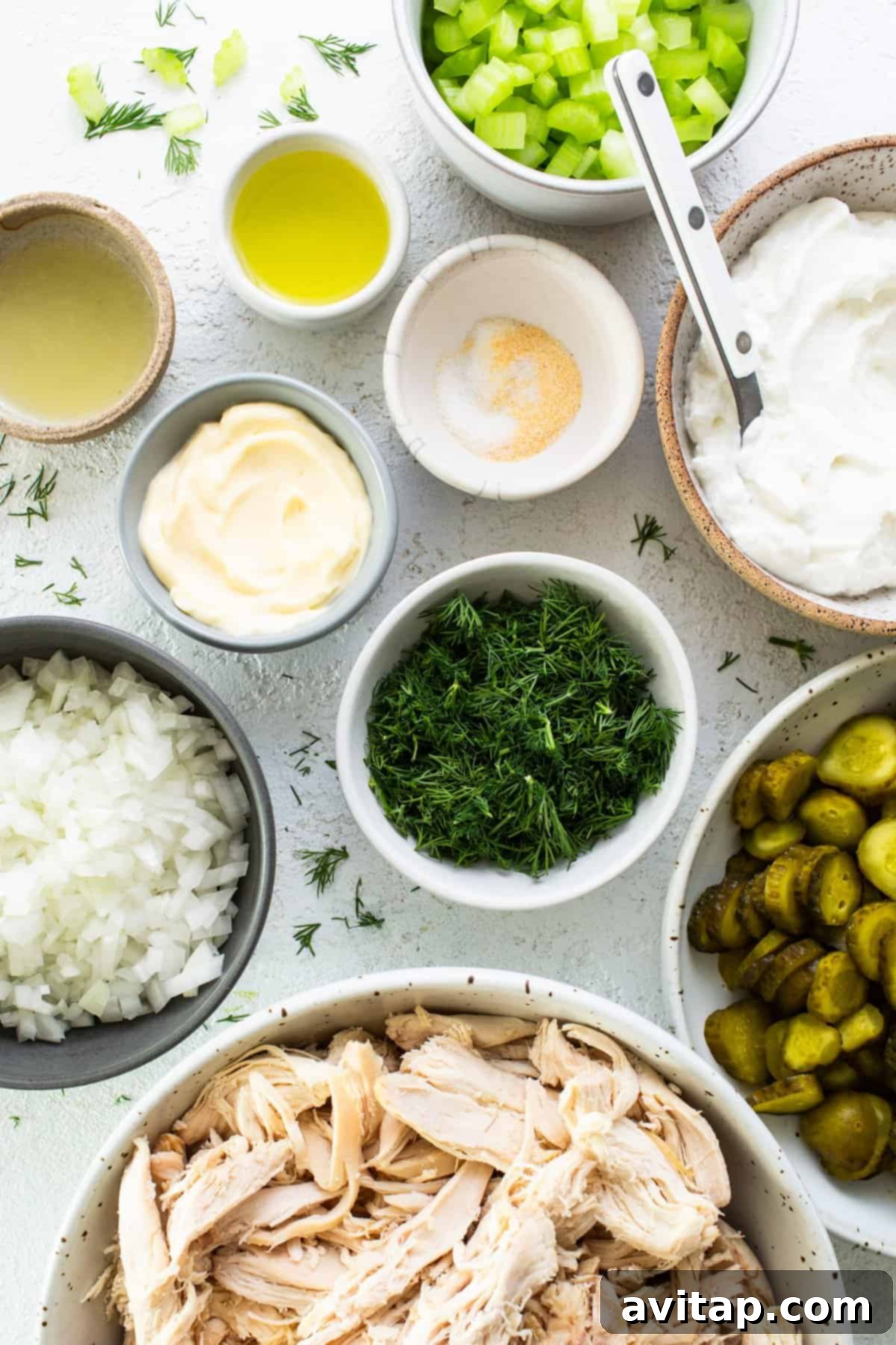 Tangy Dill Pickle Chicken Salad 3 A vibrant display of fresh ingredients for dill pickle chicken salad, including shredded chicken, chopped vegetables, and creamy dressing components.