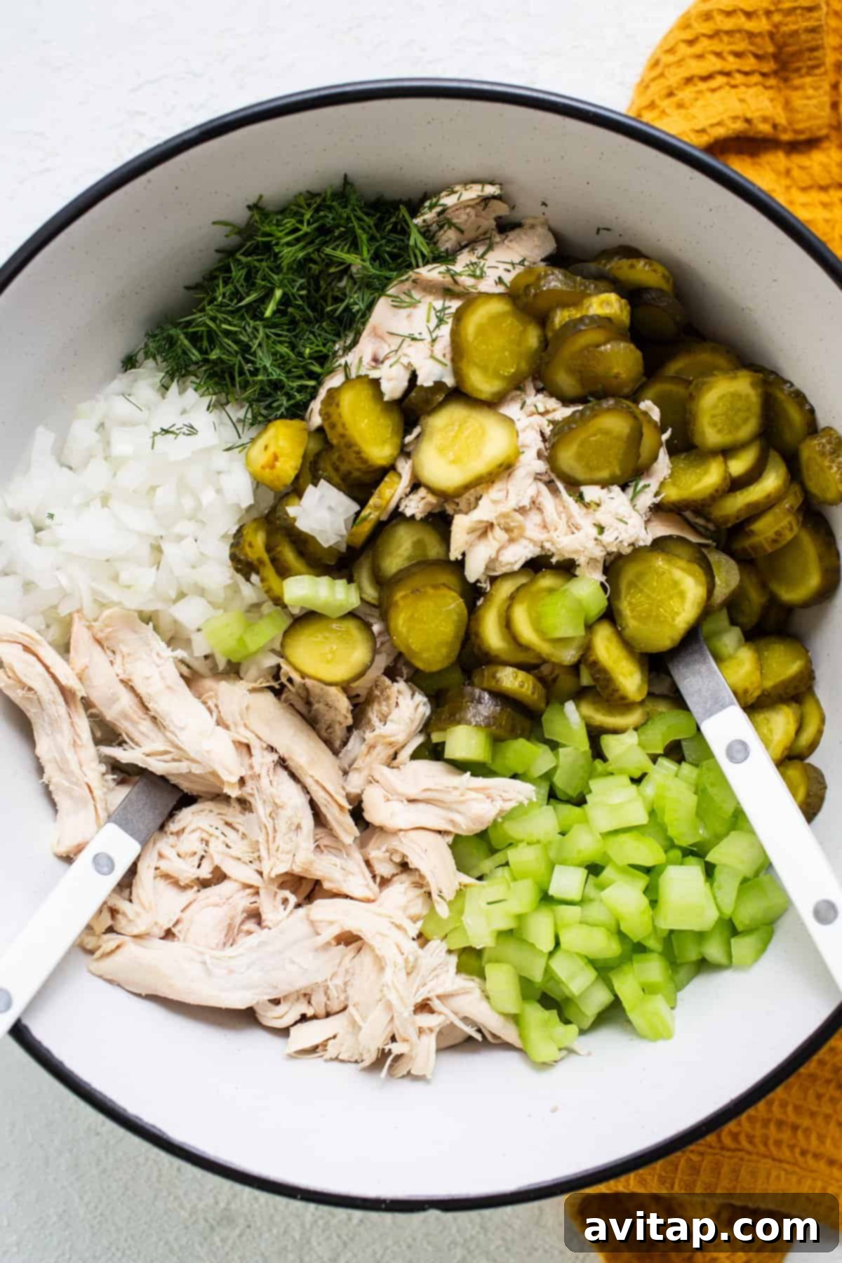 Tangy Dill Pickle Chicken Salad 4 A large bowl containing all the fresh ingredients for dill pickle chicken salad: shredded chicken, chopped onions, crisp celery, and plenty of sliced baby dill pickles.