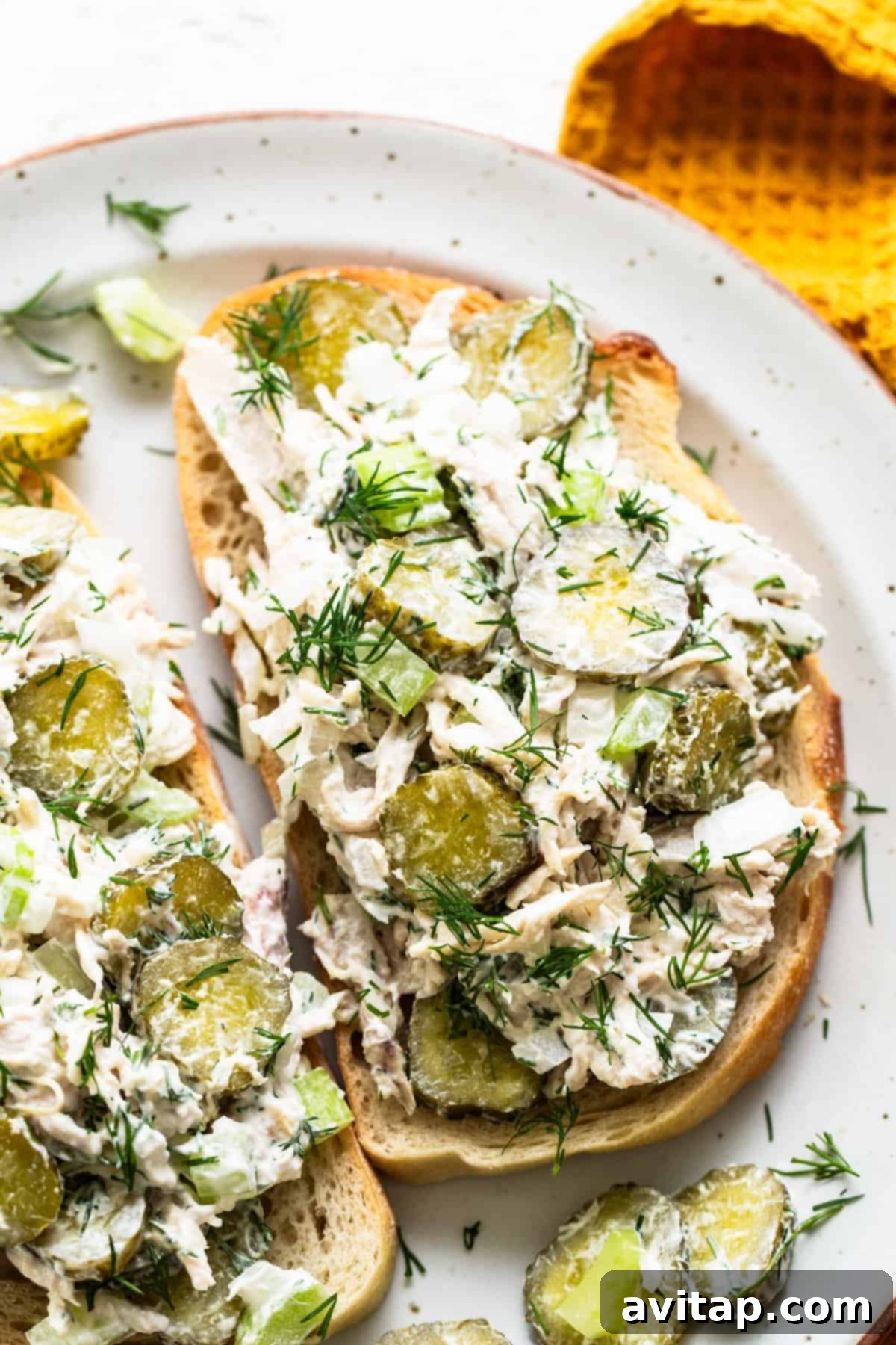 Tangy Dill Pickle Chicken Salad 6 A delicious serving of dill pickle chicken salad on golden toasted bread, garnished with fresh dill, ready to eat.