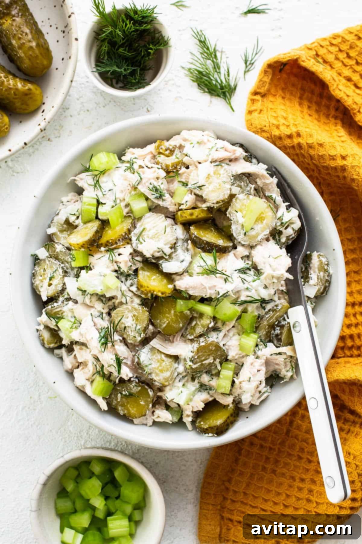 A close-up of dill pickle chicken salad served on golden toasted bread, garnished with fresh dill and pickle slices, highlighting its creamy texture and vibrant flavors.