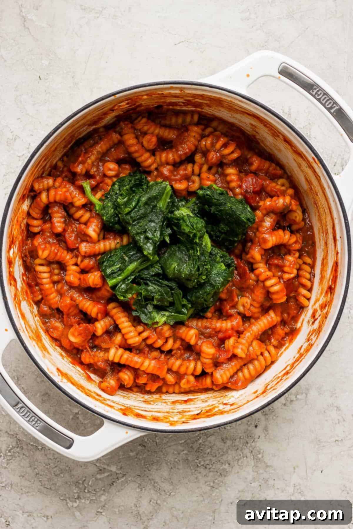 Easy One-Pot Pasta Alla Vodka 5 A creamy, tomato-based pasta dish, enriched with spinach and served in a pristine white pot, ready to be dished out.